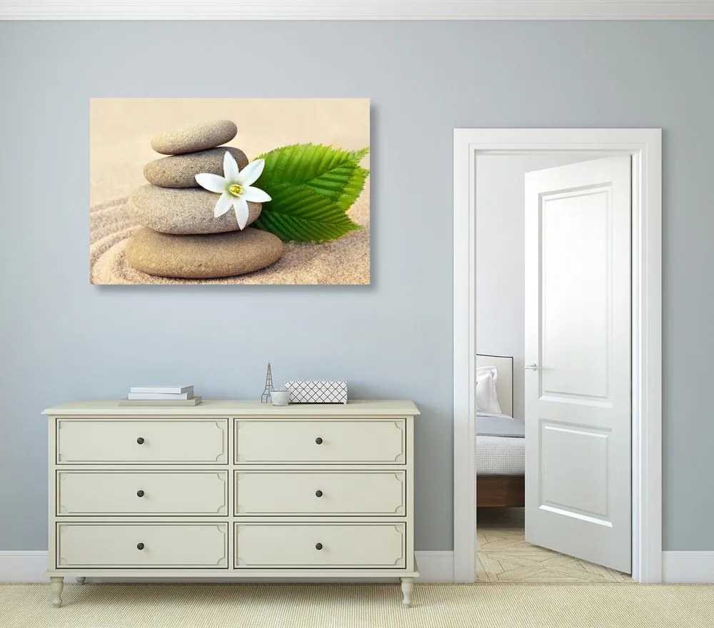 Quadro su tela – Fiore bianco e pietre nella sabbia