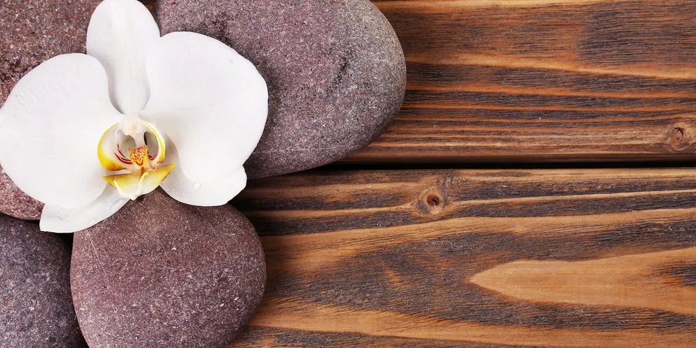 Stampa su tela – Pietre per il benessere e orchidea su sfondo di legno